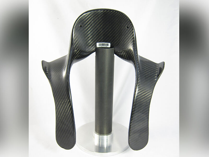 HANS device held up by a carbon fiber tube stand on a white background. Carbon fiber surface of the device is high gloss.